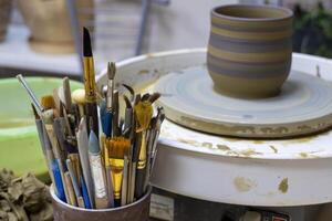 Close Up of Pottery Brushes in Studio with Clay in Background photo