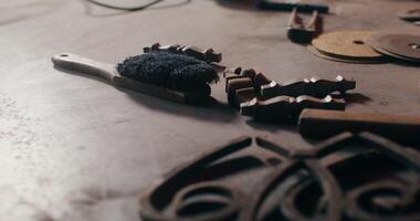 Forged metal products and working tools lie on the table of a blacksmith working on a new project. Close up of the master's desktop, no face, unrecognizable person. in 4k, red komodo photo