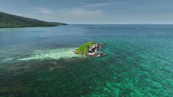 Drone shot of Camar Rock Island, a tiny rocky island in Karimunjawa. Pristine turquoise water and coral reefs surround this hidden gem in the Java Sea. video