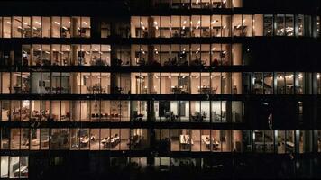 Stunning aerial view of an office building with illuminated empty offices shining bright at night close-up. video