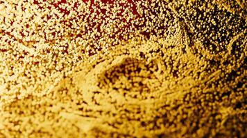 Golden particles flowing and forming dynamic shapes. Design video