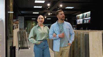Couple choosing tiles in hardware store with consultant video