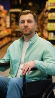Portrait of a smiling man sitting in a wheelchair in a supermarket video