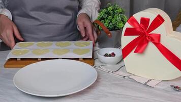 White chocolate dessert in the form of hearts and a presented box with onions in the kitchen video