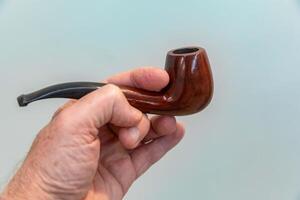 Hand holding luxurious pipe in selective focus and smooth background ABC photo