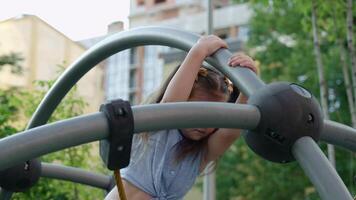 Young girl climbs a playground structure in a sunny park setting video