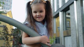 Young girl enjoys playtime at city playground during sunny afternoon video