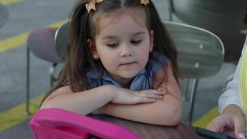 Young girl focuses intently on a colorful tablet outside during the day video