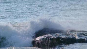 A large wave crashes over a rock in the ocean video