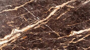 Dark brown marble with beige streaks and strong linear veining photo