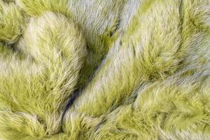 Soft fluffy green texture of green fur, warm and pleasant to the touch surface, ideal for the cold winter period or creating a cozy atmosphere in the interior, photo