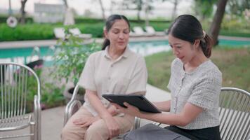 A younger woman connects with an older woman, sharing something on a tablet device. video