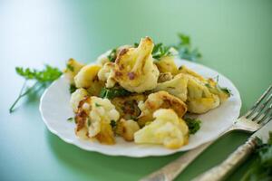 Vegetable dish of fried cabbage with aromatic spices on a green background photo
