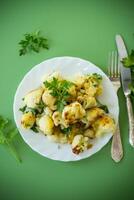 Appetizing fried cauliflower on a green background photo
