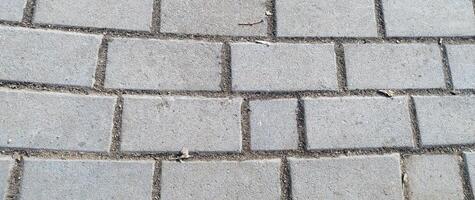 Paving stones as background or texture. Cobblestone pavement in the city. Nested pavers of Grey colors. Grey brick background. Gray stone tile block background with horizontal texture of gray brick. photo