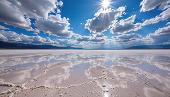 a dry salt flat stretching endlessly under a sky of mirrored clouds and blazing light. photo