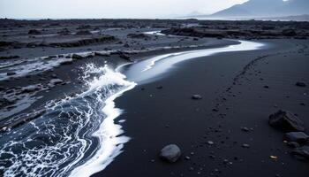 a black sand beach bordered by a lava field, where waves hiss against stone. photo