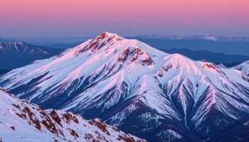 a mountain ridge covered in fresh snow and bathed in soft pink dawn light. photo
