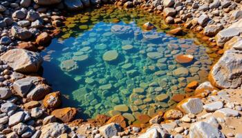 a tidal pool filled with clear water and colorful rocks. photo