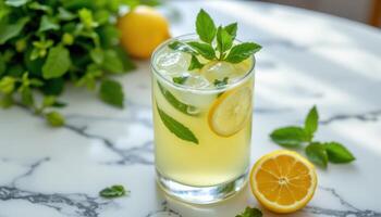 a glass of iced lemonade with mint leaves on a marble table. photo