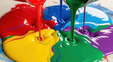 Vibrant primary and secondary colors of paint pouring and mixing together in a fluid abstract. photo