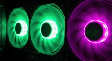 Vibrant RGB illuminated computer cooling fans in green and purple for high performance PC systems photo
