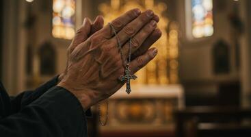 Praying hands holding a silver cross necklace inside a church, symbolizing faith and devotion. photo