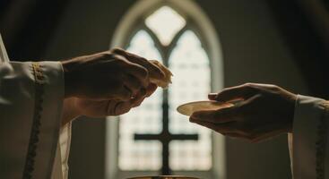 Hands of a priest offering communion bread and paten during a sacred church ceremony. photo