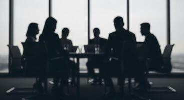 Blurred silhouettes of business professionals in a modern conference room during a corporate meeting. photo