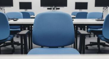 Empty modern computer lab with blue chairs and white desks for education and training photo