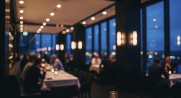 Blurred scene of a high end restaurant interior with patrons and city lights at evening photo