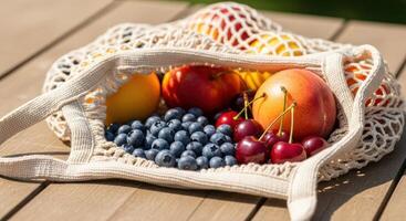 Woven Mesh Bag Overflowing with Fresh Summer Fruits on a Sunny Wooden Table photo