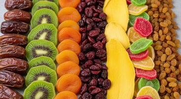 Colorful dried fruit assortment with dates, kiwi, apricots, cranberries, mango, and raisins. photo