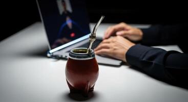 Mate Gourd and Laptop on Desk During Call for Remote Work and Productivity photo