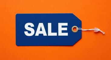 Blue Sale Price Tag with White Text on a Vibrant Orange Background photo