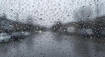 Water Droplets on Glass Surface with Blurred Outdoor Background on a Rainy Day photo