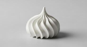 High quality studio photograph of a single white meringue cookie with a distinct swirl pattern photo