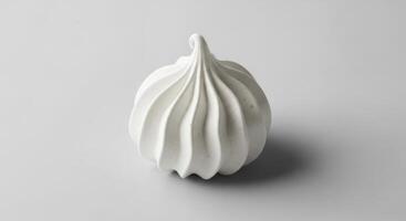 High quality studio photograph of a single white meringue cookie with a swirl pattern photo