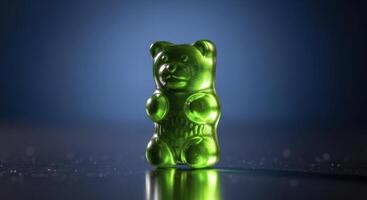Bright Green Gummy Bear Standing on Reflective Surface with Dark Blue Background photo