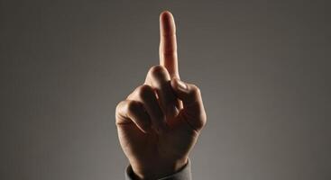 Human Hand with Index Finger Pointing Upwards Representing Direction or Number One photo