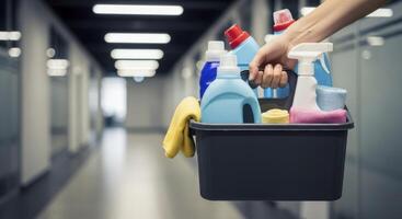 Hand holding a cleaning caddy filled with various cleaning supplies for professional or home use photo