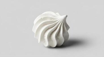 Single white meringue cookie with a distinct swirl pattern and delicate texture photo