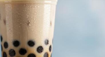 Refreshing Bubble Tea with Tapioca Pearls and Condensation on Plastic Cup photo