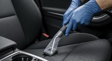 Professional Car Interior Cleaning with Vacuum by Hands in Blue Protective Gloves photo
