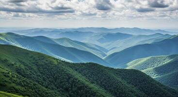 Vast green mountain ranges stretching into the distance under a cloudy summer sky photo