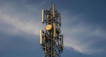 Telecommunication Tower with Antennas and Dishes Against Blue Sky for Global Connectivity photo
