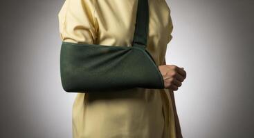 Woman wearing a green arm sling providing essential support for an injured arm during recovery. photo