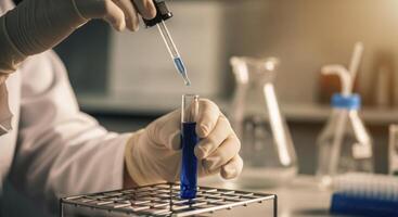 Scientist in protective gloves conducting a chemical experiment with a test tube and pipette photo