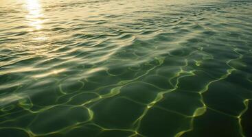 Golden Sunlight Reflecting on Clear Water Surface with Ripple Patterns photo