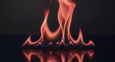 Vibrant red and orange flames with blue accents reflecting on a dark glossy surface photo